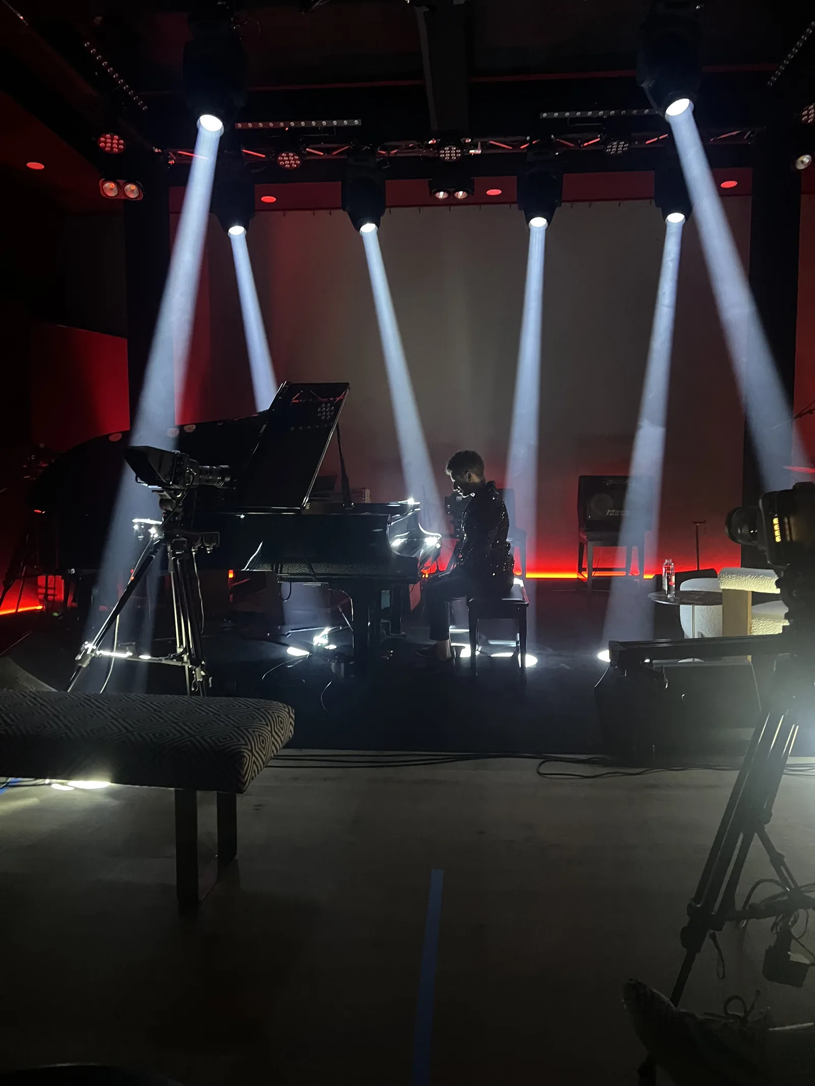 A piano on the five-camera stage at The Recording Club under beam lighting